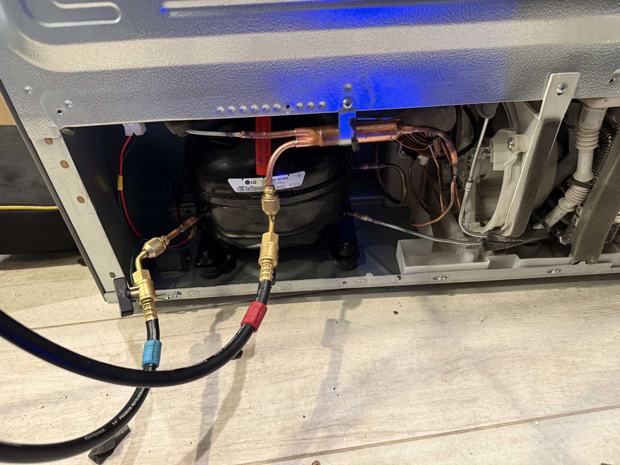 A&Y technician replacing LG compressor with refrigerant gauges