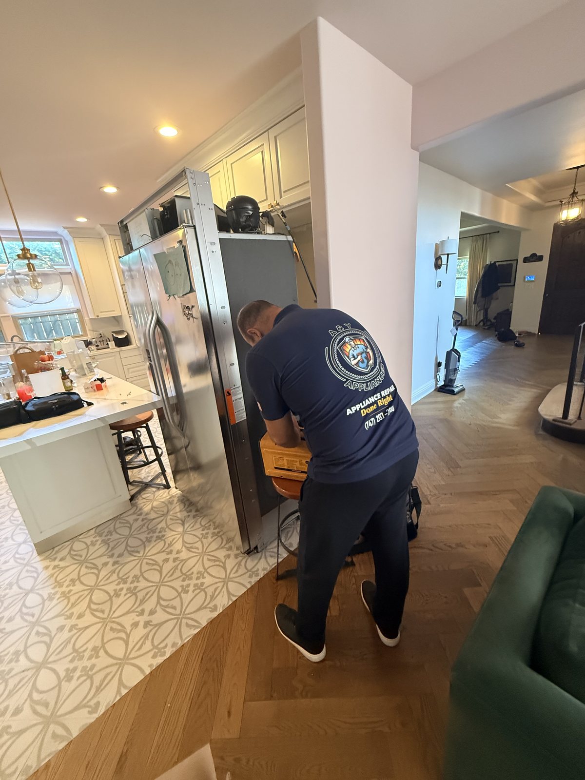 A&Y Appliances technician servicing a slid-out built-in refrigerator in a Los Angeles area home